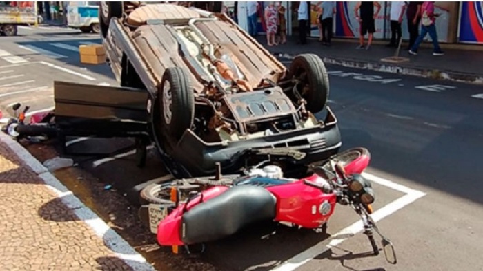 Fiat Uno é atingido por Astra, capota e derruba motos